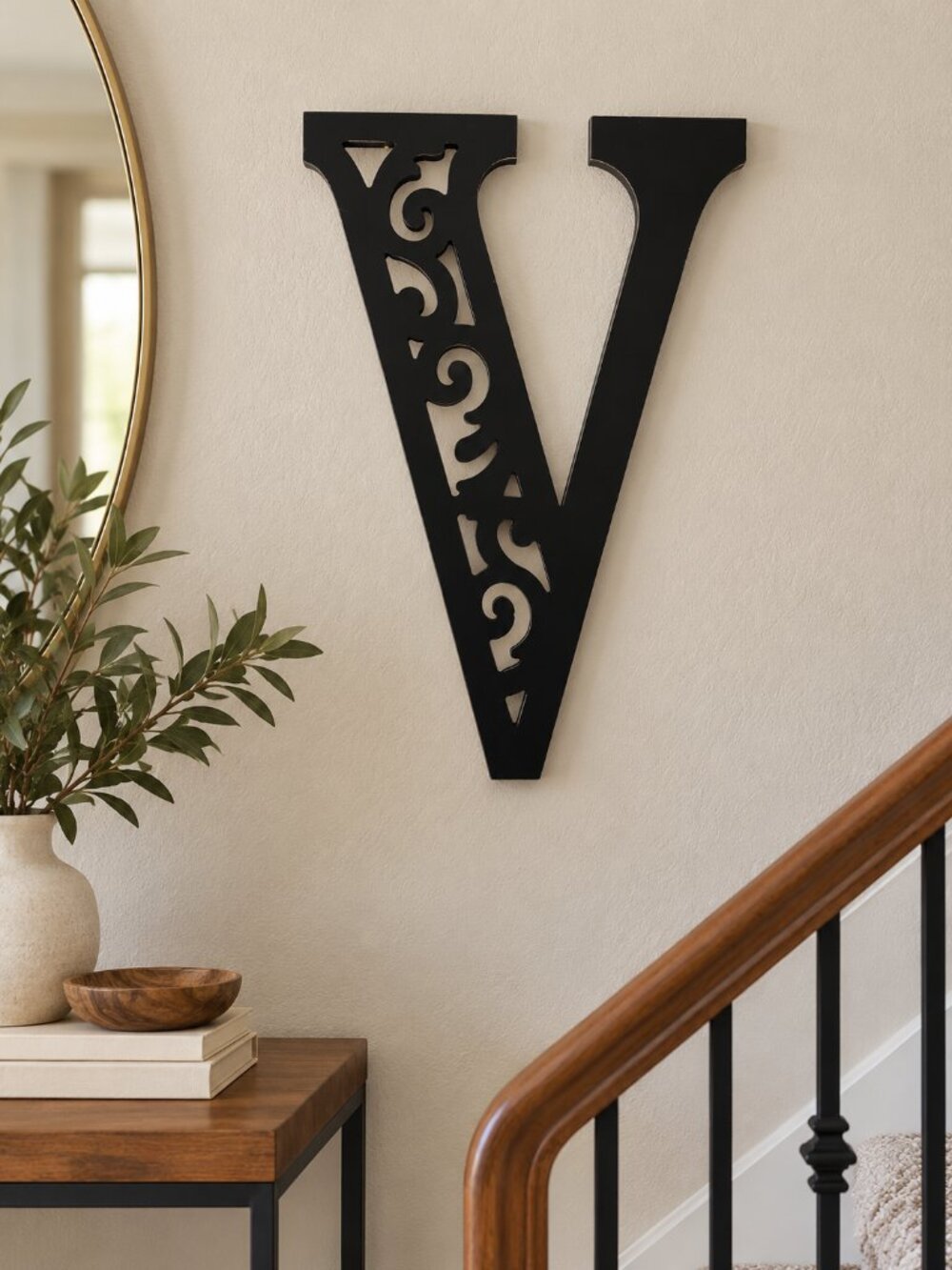 black wooden letter "V" featuring an ornate scroll and filigree cutout design